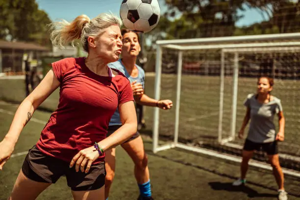 Female athlete scoring a soccer goal by heading the ball