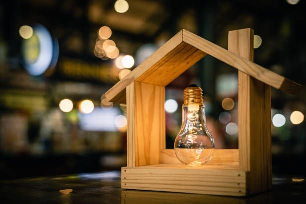 istock Light bulb with wood house on the table, a symbol for construction, Creative light bulb idea, power energy or business idea concept ecology, loan, mortgage, property or home. 1224887057