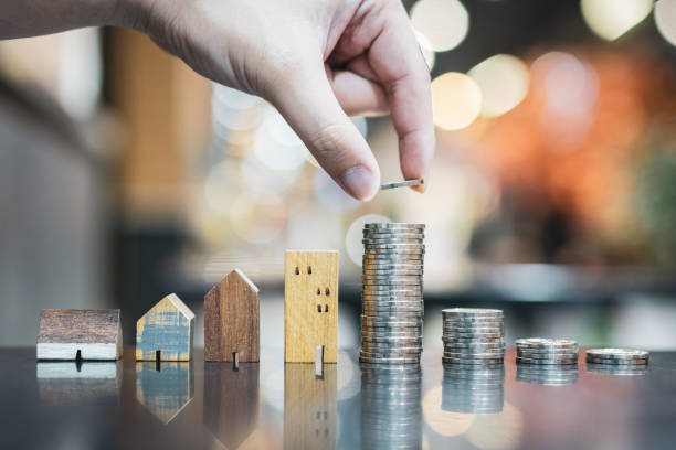 Hand choosing row of coin money on wood table and mini wood house, selective focus, Planning to buy property. Choose what's the best. A symbol for construction ,ecology, loan concepts la elección manual de la fila de dinero de la moneda en la mesa de madera y mini casa de madera, enfoque selectivo, la planificación para comprar la propiedad. elige qué es lo mejor. un símbolo para la construcción, la ecología, los conceptos de pré