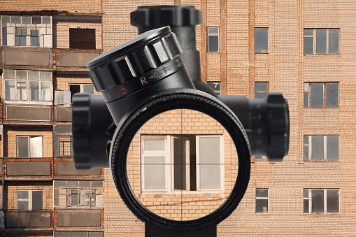 view through an optical sight at the abandoned apartment building