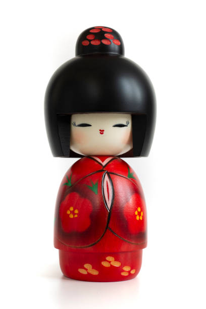 bambola kokeshi in kimono rosso su sfondo bianco - souvenir foto e immagini stock