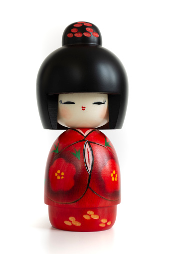 Still-life photo (taken on studio with white background and softbox) of a Japanese traditional doll isolated on white.