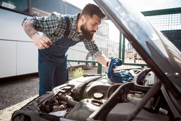 車のメカニックは、ガレージのオイルレベルをチェック - vehicle breakdown hood car oil change ストックフォトと画像