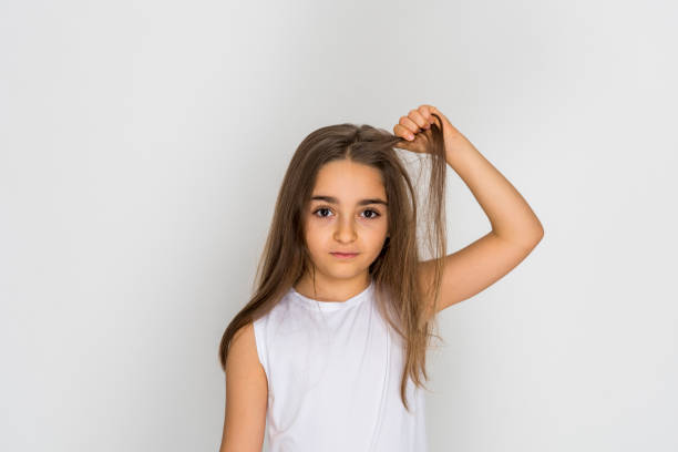 istock Little beautiful sad girl pulls her hair isolated on white background 1224889401