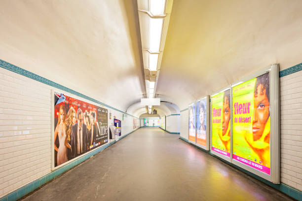 Corridor with colorful, illuminated ads in the Paris Metro (subway transit system) in downtown Paris France.