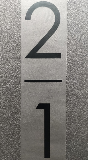 Floors in house number two and one in black on a gray wall in the entrance.