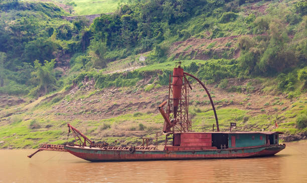 Jiangxi, China - May 04, 2012: Colour photograph of a lone fisherman wearing a red hat, casting his net out on Zhangshui River in Ganzhou city in Jianggxi (China).