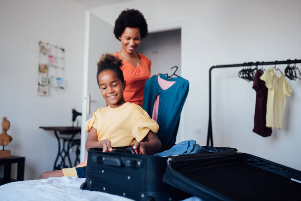 istock Mother and a daughter packing their luggage case 1224901327