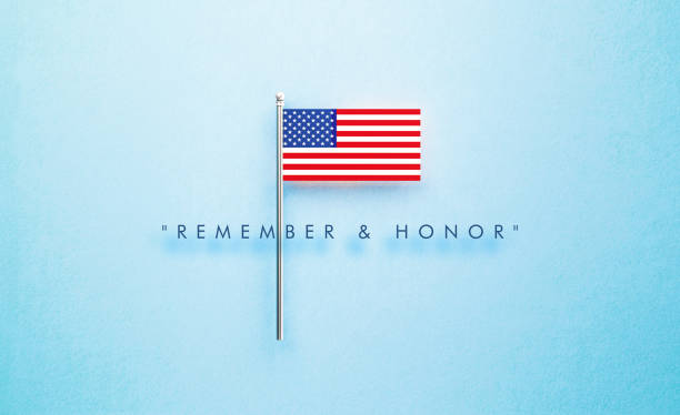 Remember and Honor Memorial Day message next to tiny American flag on blue background. Horizontal composition with copy space. Front view.
