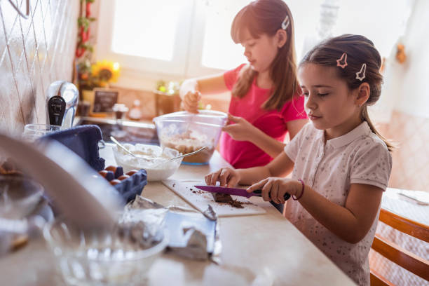 istock Girls preparing cake ingredients in the kitchen 1224913690