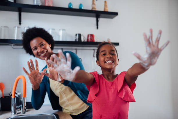 szczęśliwa rodzina afroamerykanów utrzymująca higienę przez mycie rąk - rubbing human hand togetherness women zdjęcia i obrazy z banku zdjęć