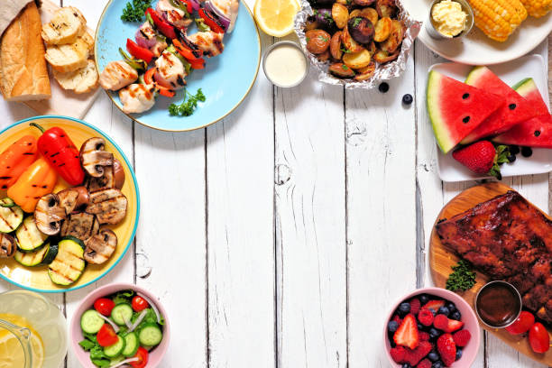 istock Summer BBQ or picnic food frame over a white wood background 1224920724