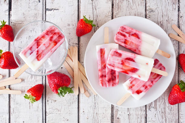 istock Homemade strawberry vanilla yogurt popsicles, top view scene on rustic white wood 1224920938