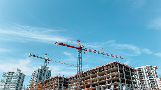 Cranes in a construction area with blue sky as background