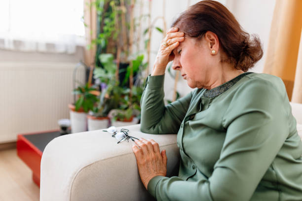 en upprörd senior woman lider av migrän - stressad äldre man bildbanksfoton och bilder