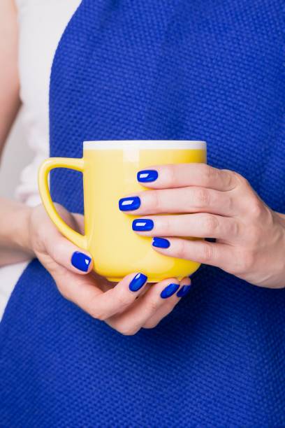 istock Beautiful female hands holding yellow cup 1224922557