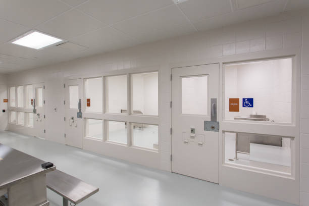 Modern Jail Holding Cell. Interior space is sparse, white minimal, and clean. stock photo
