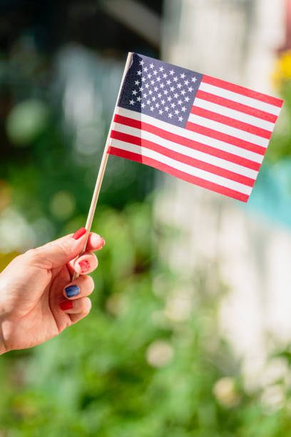 istock Woman's hand holding an American flag 1224923970