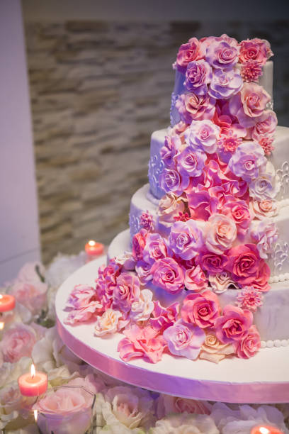 istock White wedding cake with pink roses around it 1224925719