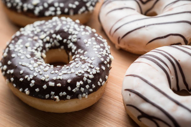 istock Black and white chocolate doughnuts on a wood table 1224925733