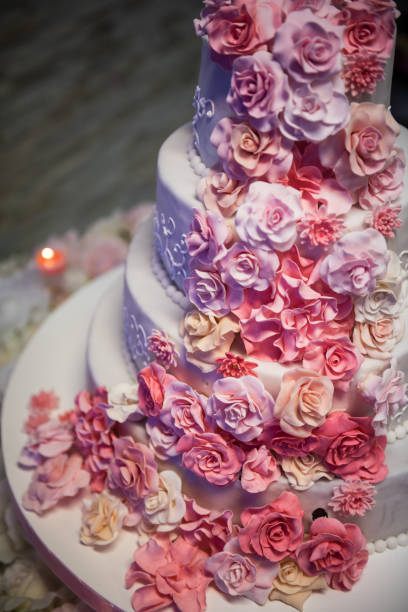 istock White wedding cake with pink roses around it 1224925764
