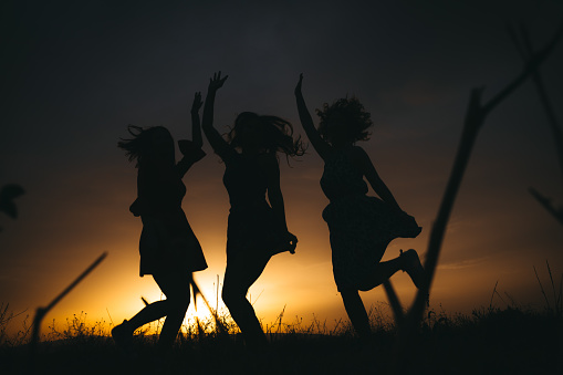 Silhouette girls standing on mountain and rise up her hand