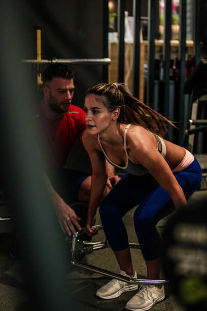 istock Personal trainer assisting fit young woman while she is doing deadlifts 1224927446