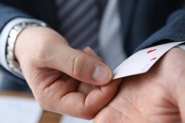 istock Closeup man in suit hiding ace card in sleeve 1224927514