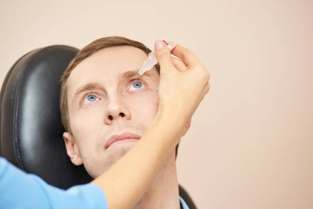istock Doctor hold eye drops near patient face 1224927526