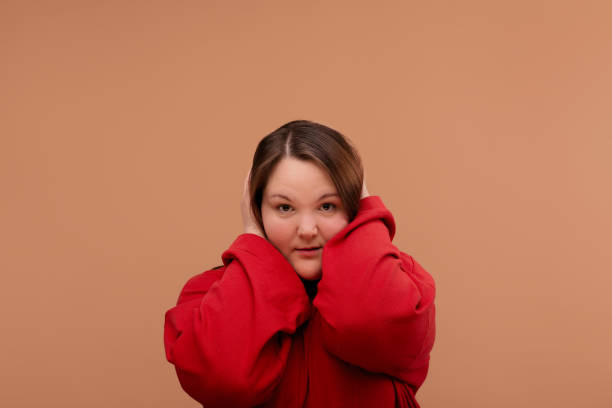 istock A beautiful young girl embraced herself with her hands. Red jacket 1224927952