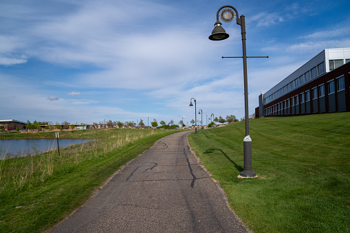 Maple Grove, Minnesota - May 14, 2020: Walking trails in the Arbor Lakes area of the Twin Cities. Focus on the first lamp post