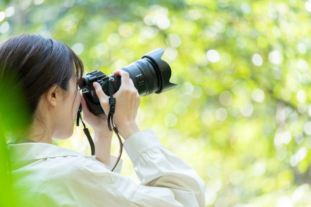 istock Young woman holding a camera in nature 1224931053