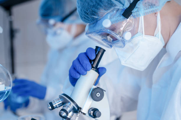 istock biochemical research scientist team working with microscope for coronavirus vaccine development in pharmaceutical research labolatory, selective focus 1224931070