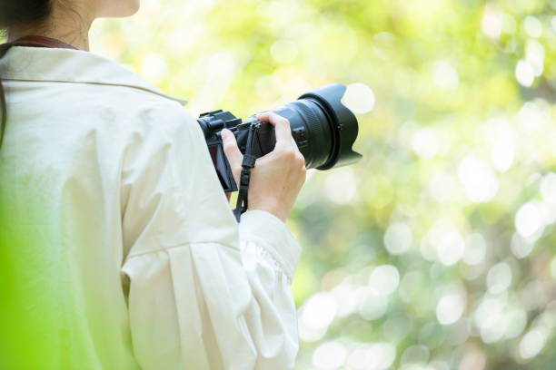 自然の中でカメラを持っている若い女性 - 写真撮影 ストックフォトと画像