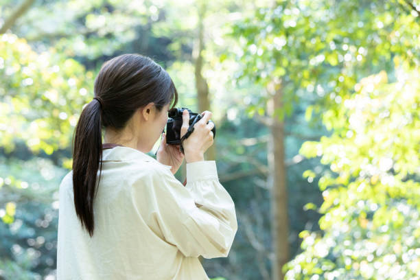 istock Young woman holding a camera in nature 1224931080