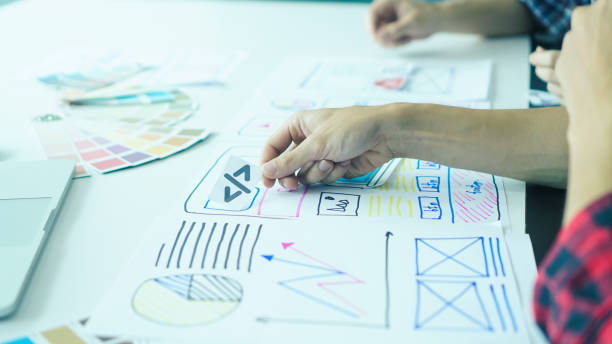 Designers man drawing ui/ux designers working and designing user interface for website and application, working together with partner planning and brainstorming sketch designs with computer laptop. el hombre diseñador es dibujante que dibuja diseñadores ui/ux trabajando y diseñando la interfaz de usuario para el sitio web y la aplicación, trabajando junto con la planificación de socios y la lluvia de ideas diseños de bocetos con computadora por