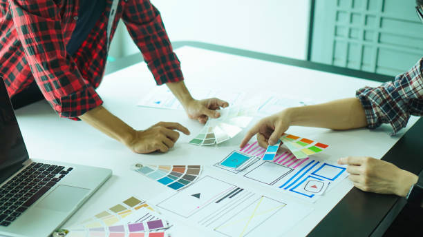 istock Designers man drawing ui/ux designers working and designing user interface for website and application, working together with partner planning and brainstorming sketch designs with computer laptop. 1224932678