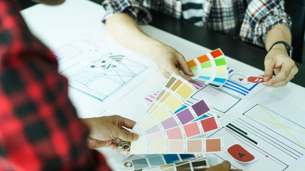 istock Designers man drawing ui/ux designers working and designing user interface for website and application, working together with partner planning and brainstorming sketch designs with computer laptop. 1224932685