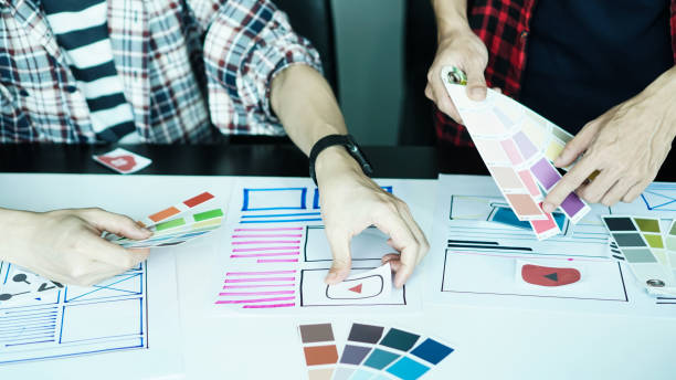 istock Designers man drawing ui/ux designers working and designing user interface for website and application, working together with partner planning and brainstorming sketch designs with computer laptop. 1224932687