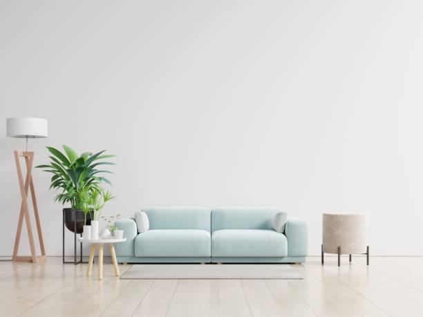 istock Empty living room with blue sofa, plants and table on empty white wall background. 1224936274