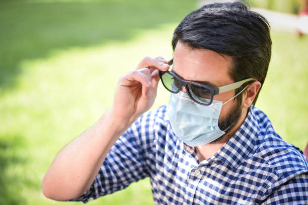 istock Covid-19 life - Man with a face mask is sitting in a park alone and practicing social distancing - Covid life 1224938258