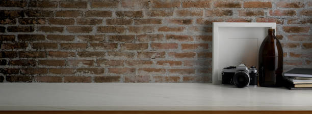 istock Close up view of contemporary worktable with decorations on marble desk with brick wall 1224942220