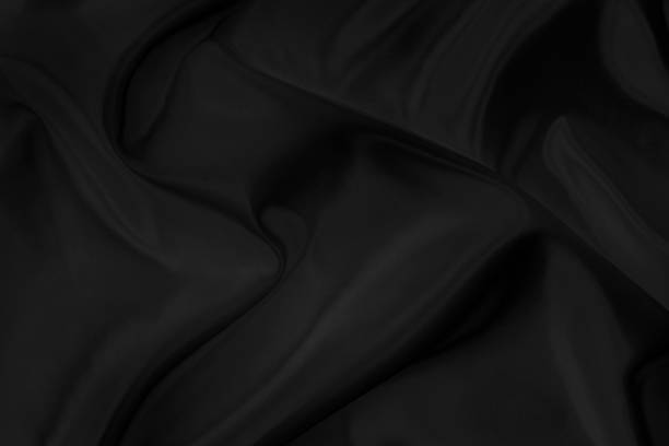 istock Black gray satin dark fabric texture luxurious shiny that is abstract silk cloth background with patterns soft waves blur beautiful. 1224944768