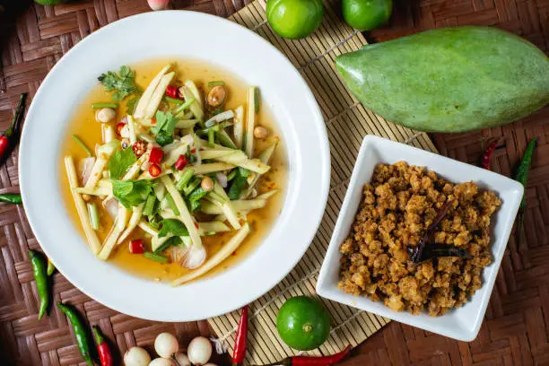 Photo of The popular food of Thailand. Crispy Catfish Salad on wooden background.