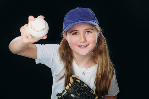 istock A smiling nine years old girl is throwing a baseball. 1224948912