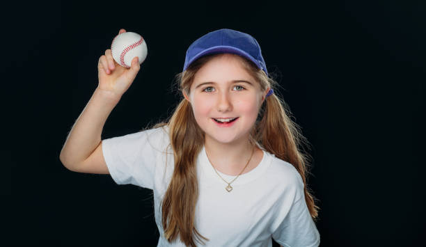 istock A smiling nine years old girl is throwing a baseball. 1224948943