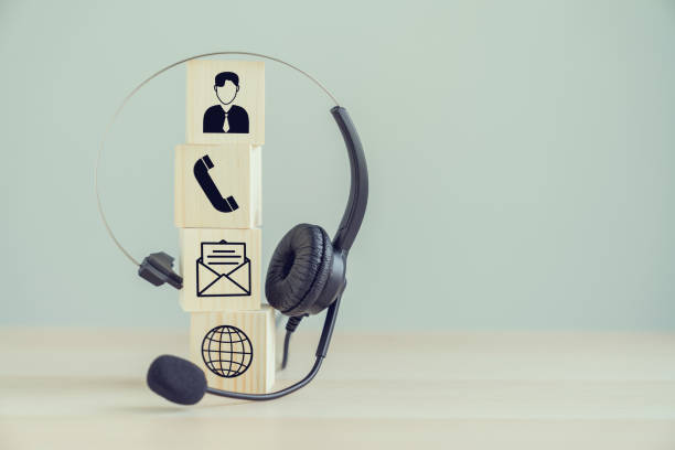 istock VOIP headset and Icon communication on the wood block. 1224950573