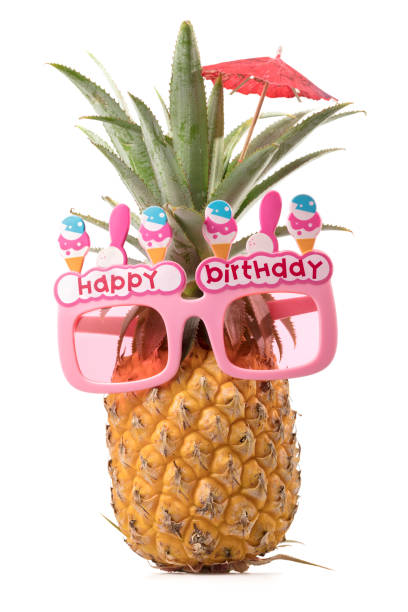 Pineapple with Happy birthday sunglasses isolated on white background, vertical composition stock photo
