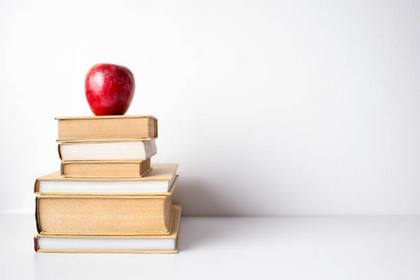 istock Books stuck with red apple with copy space, isolated on white background 1224952551