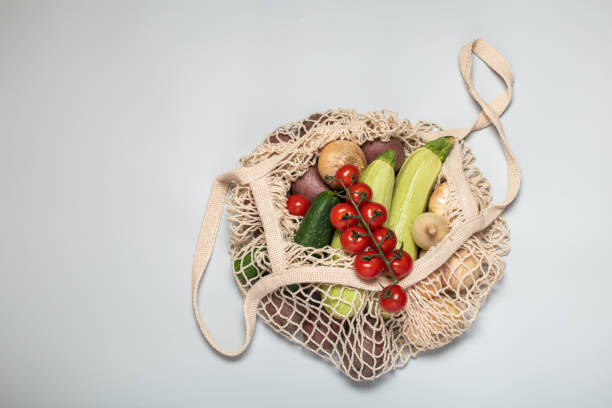 istock Eco-friendly vegetables in a reusable bag on a gray background. Caring for the surrounding family and rejection of plastic. Copy space 1224953328